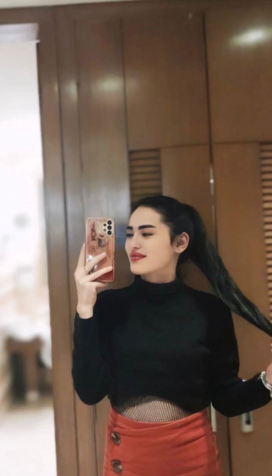 Sexy woman posing for a mirror selfie with long ponytail