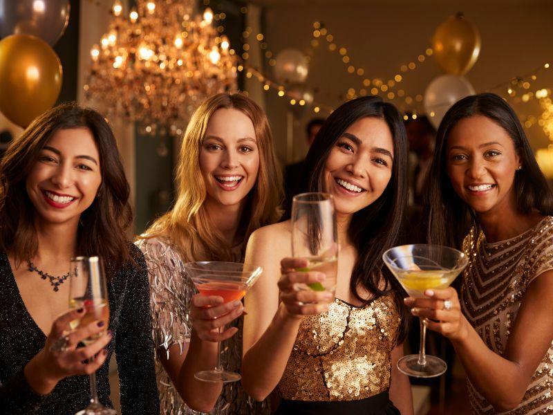 Women celebrating with drinks at night event