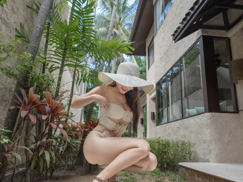 Bold woman sitting near villa garden in sunlight