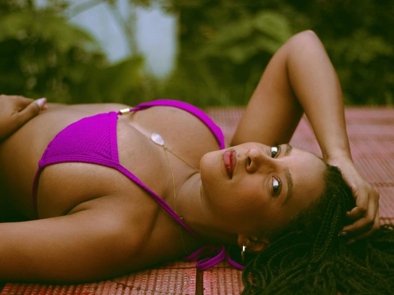 Woman in pink bikini lying relaxed on mat outdoors