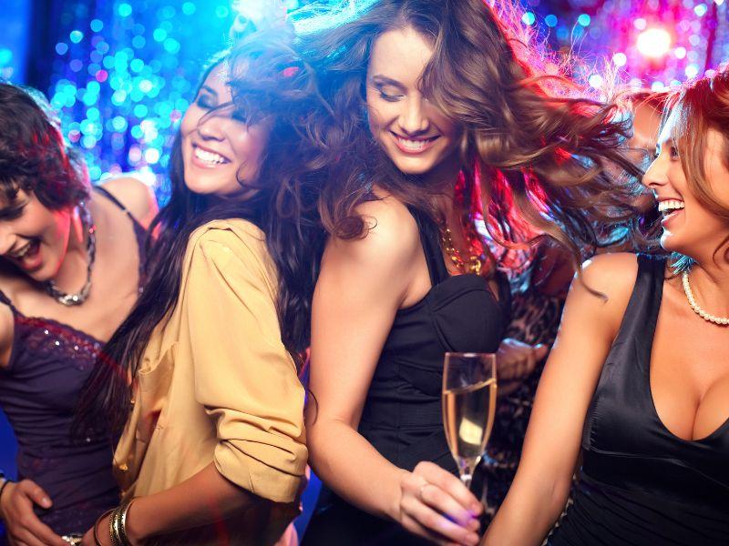 Women enjoying vibrant nightlife with drinks
